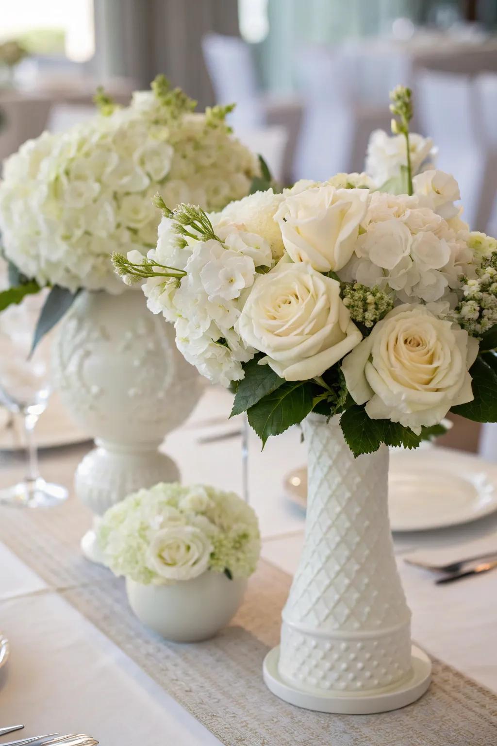 White flowers serve as a breathtaking centerpiece for an all-white dinner table.