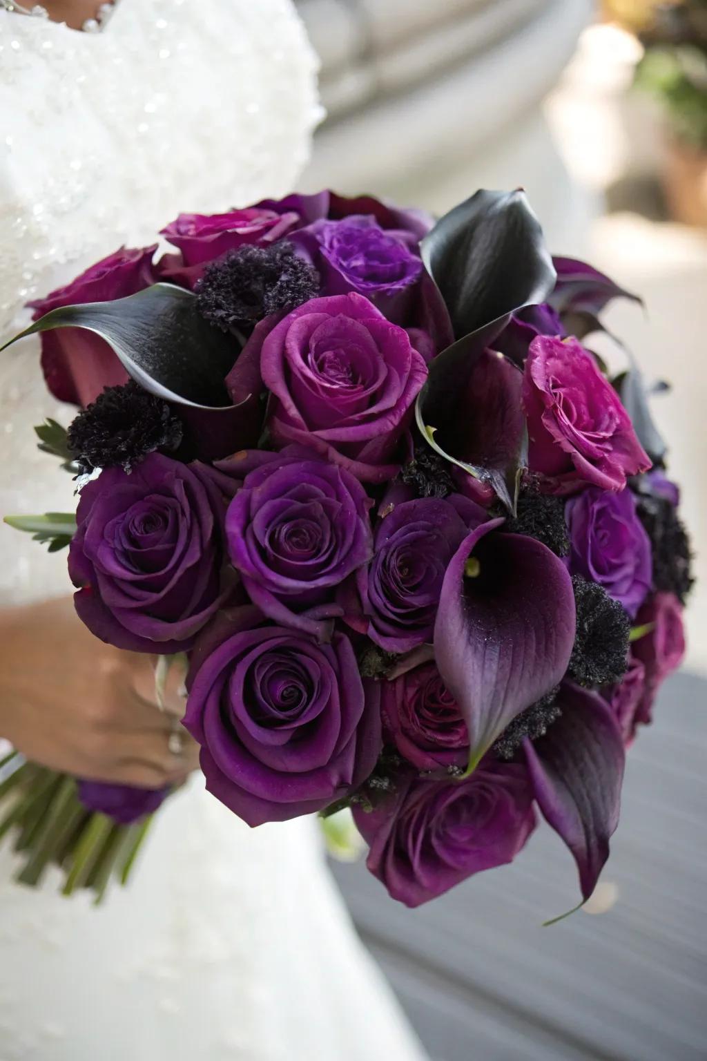 A breathtaking arrangement of deep purple roses and black calla lilies.