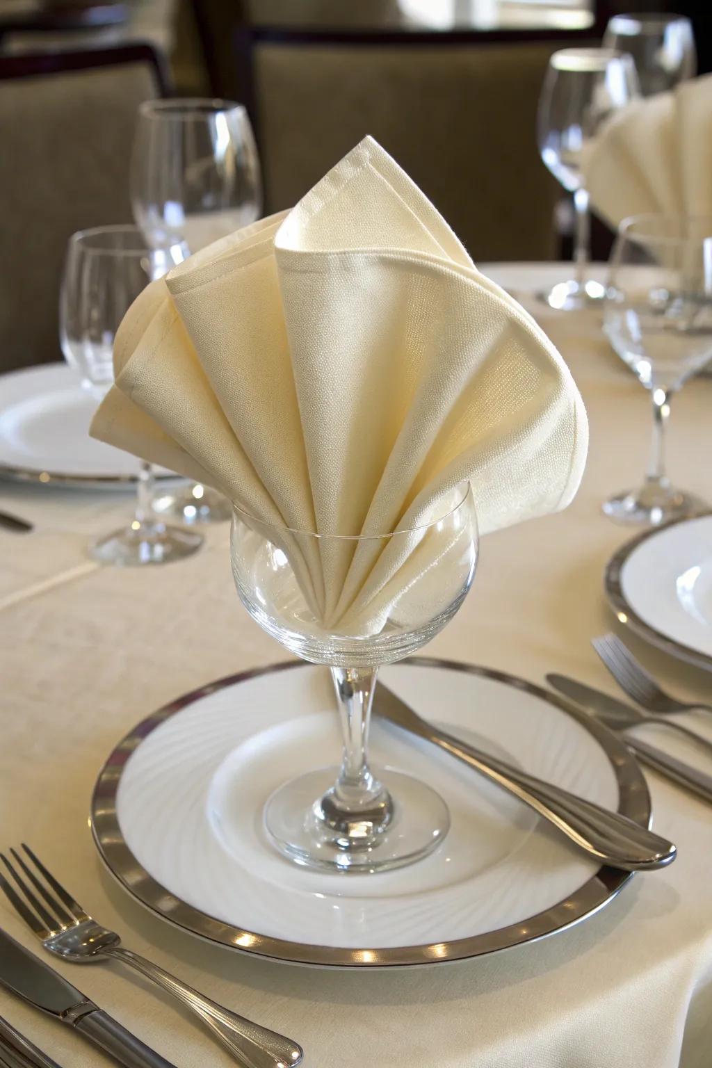 A cloth gracefully styled into a standard fan, giving style to the dining scene.