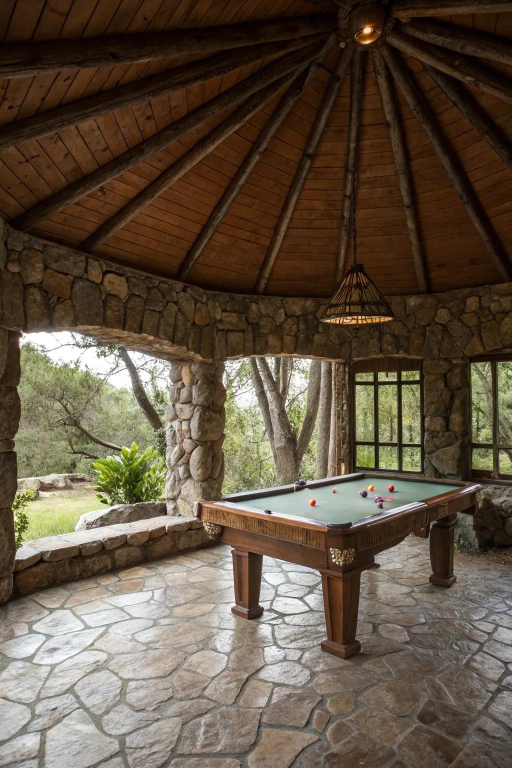 A down-to-earth stone gazebo housing a pool table in a natural setting.