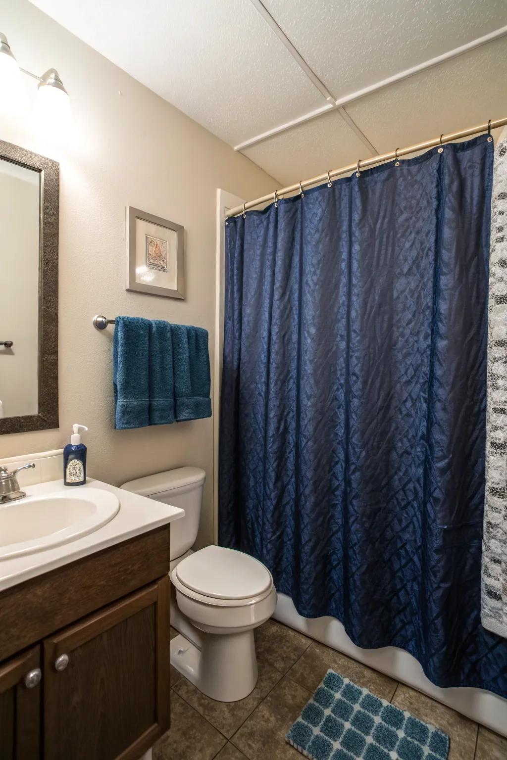 Dark blue shower drapes inject a bold declaration to this compact bathroom.