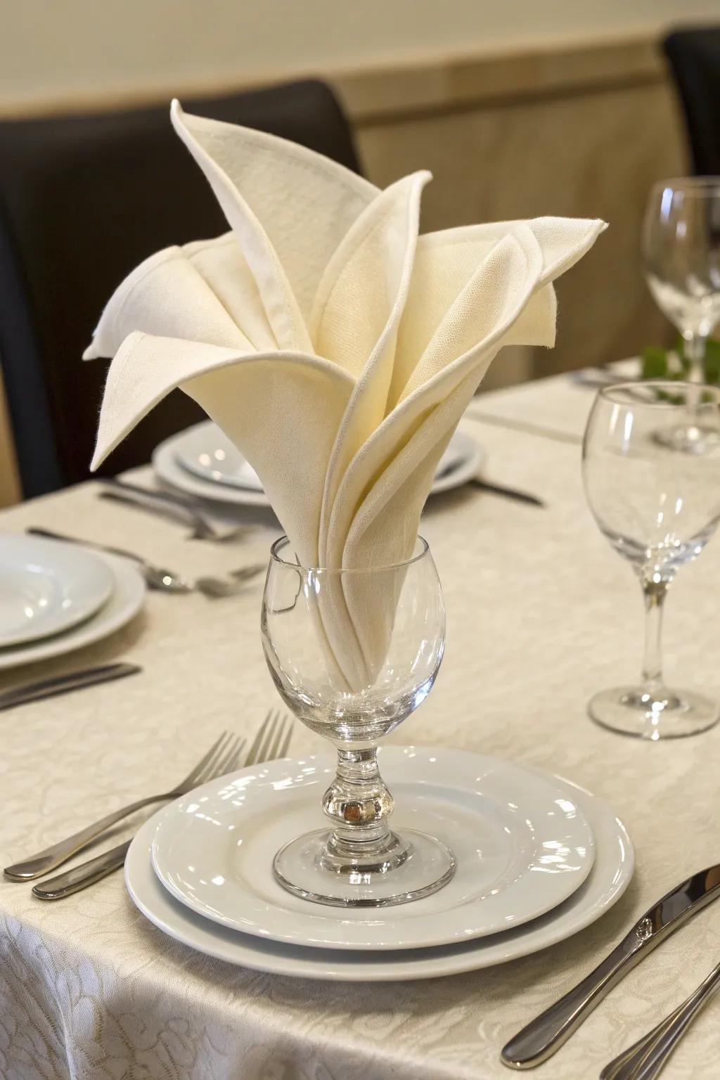 The floral chalice napkin fold introduces a floral touch to your setting.